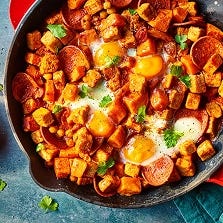 Vegetarian Hash with Quorn Pieces and Pepperoni served in a frying pan with mint leaves.