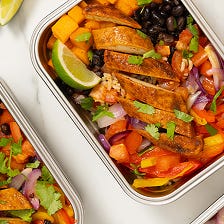 Quorn burrito bowl recipe idea: Quorn Pieces served on a bed of rice with black beans, onions, and red and yellow peppers.